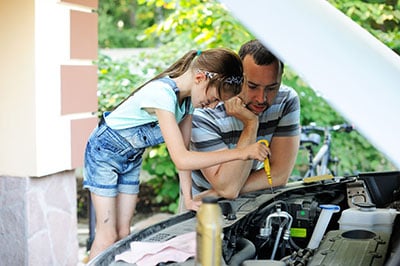 Father and daughter repairing the car together